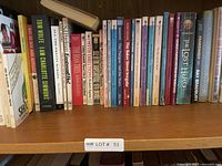 Shelf of assorted books showing a variety of titles including fiction and non-fiction works by various authors.