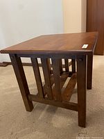 View of small wooden end table showing side with vertical wood slats and sturdy construction typical of Mission style furniture.