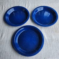 Top view of three blue enamel plates