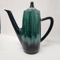 Front view of Blue Mountain drip-glaze teapot showing spout, body, lid