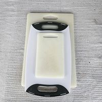 All three cutting boards stacked to show relative sizing and handle styles