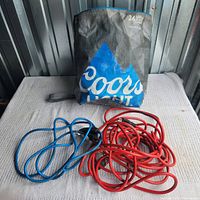 Overall items: cooler bag standing with blue and red extension cords