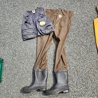 Full view of Red Ball chest waders and SportFisher vest laid out on ground