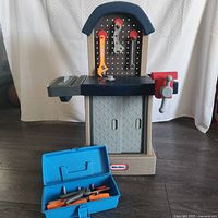 Full view of Little Tikes workbench and blue toolbox on floor