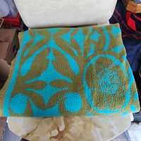 Blanket folded showing green and aqua floral pattern