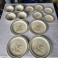 All 13 dinnerware pieces laid out showing sizes and pattern