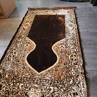 Full view of brown and beige velvet prayer rug showing overall design and fringe