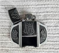 Belt buckle with lighter inserted and lid open showing matching design