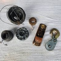 Overview of all items: three wire coils, pulley wheel, block plane, lifting hook with pulley