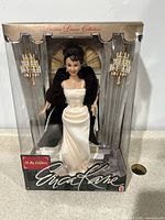 Front view of boxed Barbie Erica Kane doll with detailed outfit and display background visible.