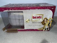 Photo of original packaging showing Bratz The Movie Party Bus with empty window spot to view toy inside.