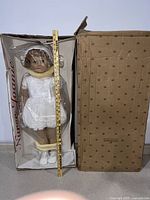 Full-length front view of Nurse Joanie doll in original box with ruler