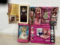 Photo showing all boxed dolls and Barbie Build A Room Kit arranged on counter