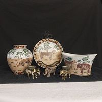 Full front view of all 6 items showing animal and palm tree designs on vase, plate, planter, and 3 animal-shaped candle holders.