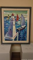 Full view of the oil painting showing the Port Credit lighthouse and sailboats on the water, framed with mat and outer frame.