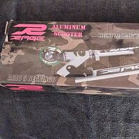Photo of the Rage aluminum scooter in closed box showing branding and features including ABEC 5 bearings and lightweight frame.