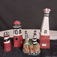 Front view of all lighthouse ceramic pieces showing decanter, salt and pepper shakers, and island base with spreaders