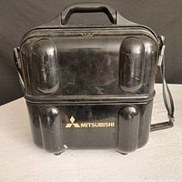 Closed Mitsubishi hard shell carrying case for the video camcorder.