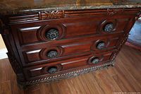 Front view showing mahogany dresser with 3 drawers and round carved wooden handles along with marble top.