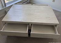 Top view of the square wooden coffee table showing two drawers pulled out.