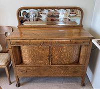 Front view of oak dresser with attached mirror showing drawer and cabinet configuration