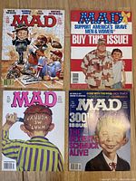 Four Mad Magazines shown from the front covers with various 1990s pop culture images and humorous illustrations.