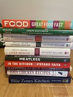 Stack of nine cookbooks showing titles and authors