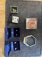 Overview of all jewelry in the lot on gray surface including earrings, necklaces, bracelet, and pins.