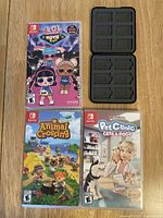 Front view of three Nintendo Switch game cases: LOL Surprise! Movie, Animal Crossing New Horizons, My Universe Pet Clinic Cats & Dogs, with two black game card holders on right.