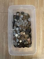 Plastic container filled with assorted British coins top view