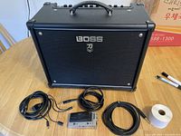 Front view of Boss Katana-50 MkII combo amplifier with three cables and FS-7 footswitch laid out on table