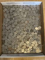 Overhead view of unsorted US quarters in cardboard box