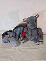 Photo showing the handmade gray squirrel plush sitting with its denim mushroom plush beside it on a light surface.