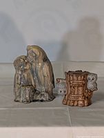Two owl-themed vintage items, one glazed ceramic figurine of two owls and one piggy bank shaped like a wooden stump with owls.