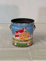 Front view of vintage Barbour's peanut butter tin with original colorful label and metal handles.