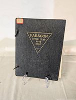 Closed front cover of Paragon loose leaf note book showing black textured cover with gold printed logo.