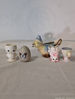 Front view of six vintage ceramic Easter-themed figures arranged in a row on a light surface with a plain background.
