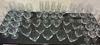 Top view of the 48-piece set of clear glassware arranged in rows showing the wine, water, champagne, and highball/martini glasses.
