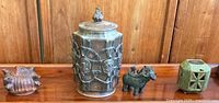Four pieces including a hexagonal ceramic urn, bronze ram figurine, a green ceramic candle holder, and a carved wooden pot with four spouts.