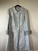 Full view of platinum blue silk coat with silver mink trim on cuffs, single-breasted button closure, and straight cut design