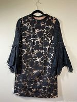 Front view of the champagne lining dress with black sheer floral overlay and handkerchief sleeves