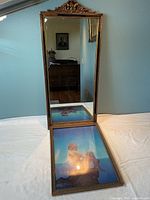 The mirror standing upright with the Parrish print reflected in it.