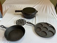 Overview of all items: deep pan with shallow pan lid, Lodge pan, Jotul pan, and trivet