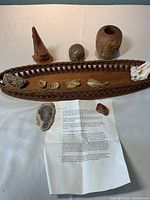 Lot showing wood bread basket, fossils, polished agate stone, petrified wood, wooden vase, and wood carving with hollow center. Includes provenance document.
