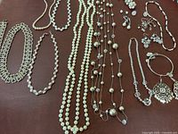 Overview of necklaces, earrings and bracelet on red surface