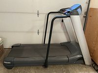 Full side profile of Precor Precision Low Impact treadmill in gray and black with safety rails and running belt.