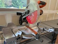 Full view of saw on table showing sliding miter base, fence and clear blade guard