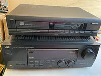 Magnavox CDE 500 CD player stacked on top of JVC RX-77V receiver, showing front control panels and buttons.