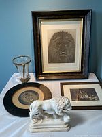 Full view of all items including the three framed lion artworks, alabaster lion statue, and crackle glass vase in brass frame with lion head details.