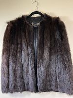 Front view of vintage black fox fur short cape on hanger